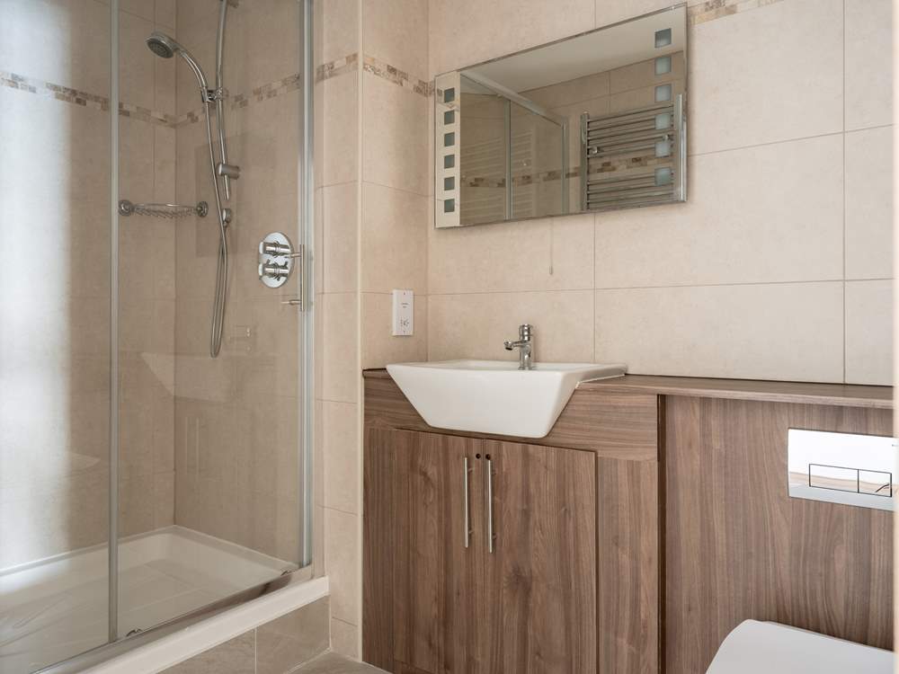 The family bathroom sits opposite the twin room offering a shower cubicle and bath.