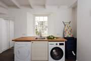 The utility-room has a washing machine and tumble-drier.