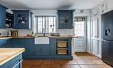 The stylish kitchen has all you need, and a washing machine and drier behind the doors next to the back door.  - Thumbnail Image