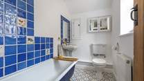 The family bathroom has a bath with a fitted shower. 
