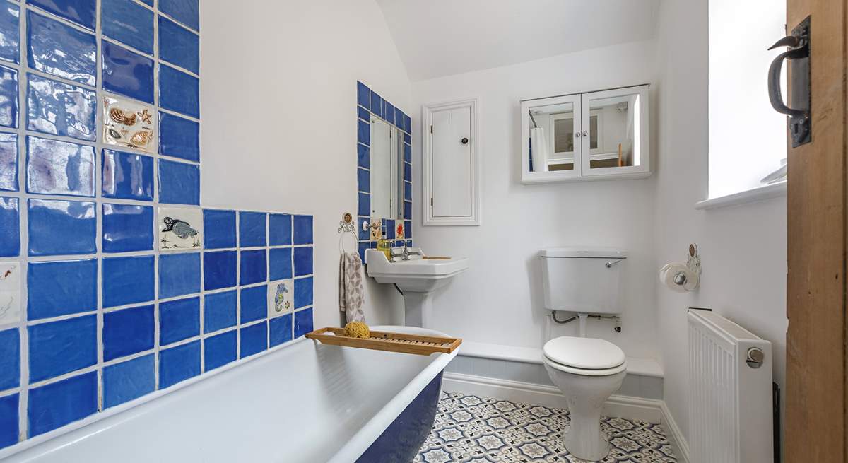 The family bathroom has a bath with a fitted shower. 