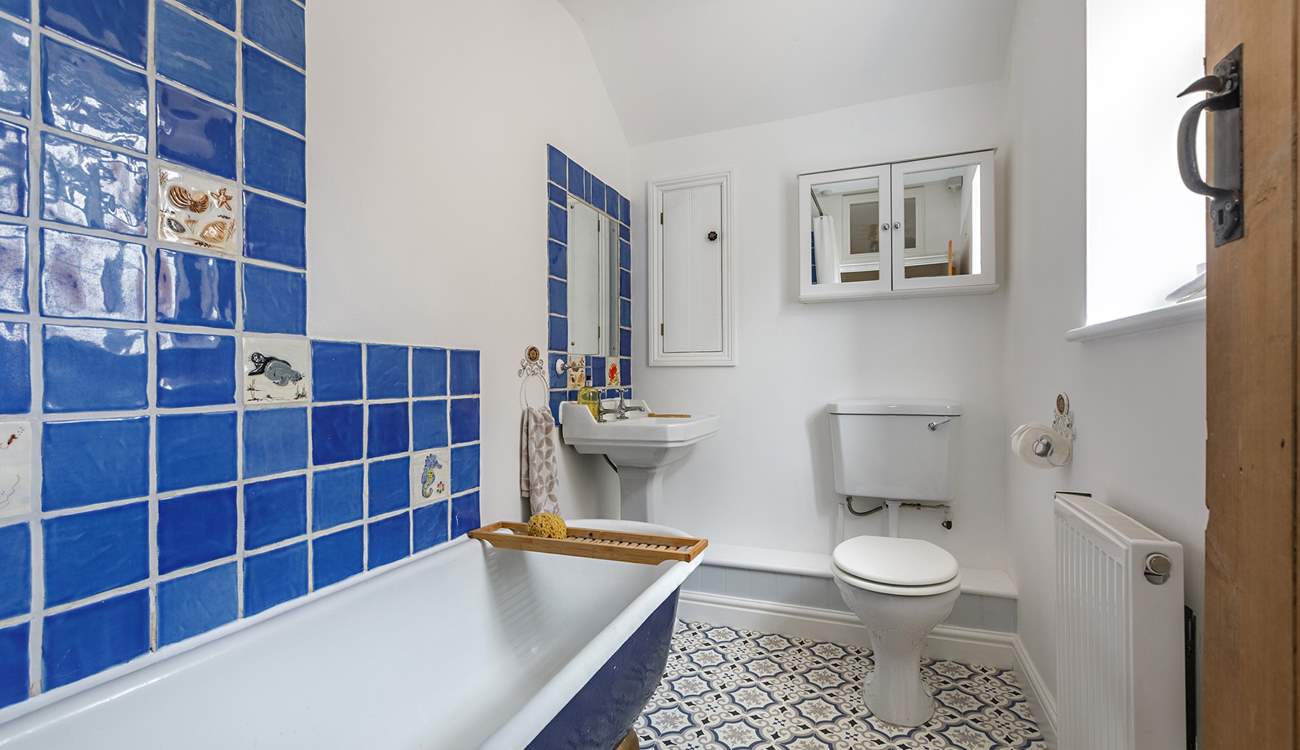 The family bathroom has a bath with a fitted shower. 