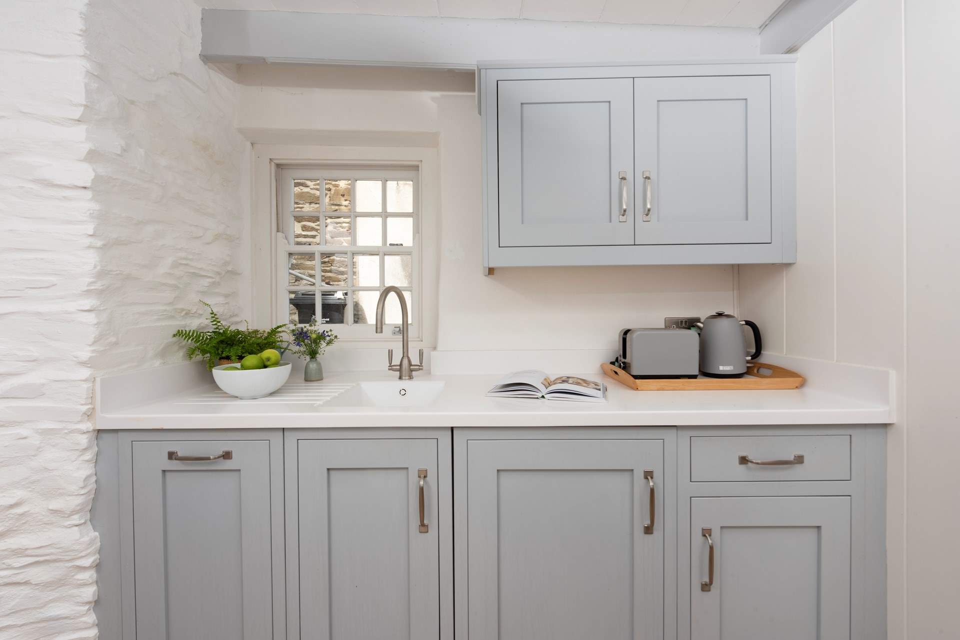 The kitchen is presented in stylish pastel tones.