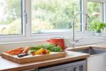 Prepare a meal in the kitchen while admiring the beautiful garden outlook.