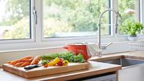 Prepare a meal in the kitchen while admiring the beautiful garden outlook.