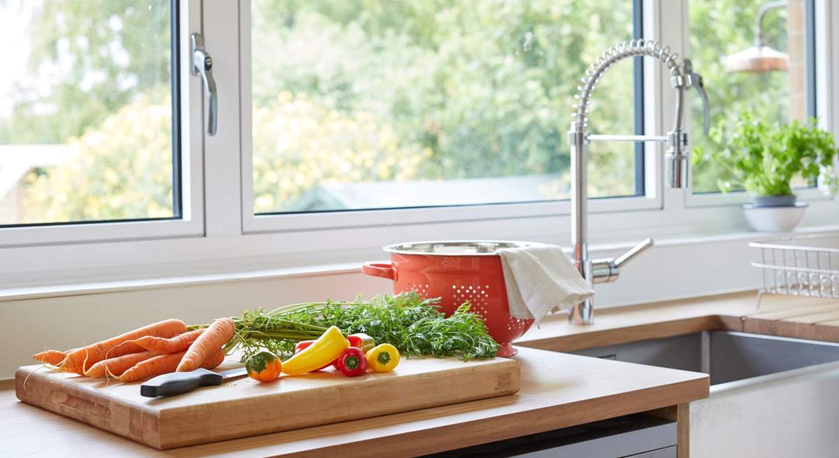 Prepare a meal in the kitchen while admiring the beautiful garden outlook.