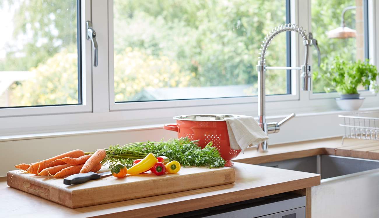 Prepare a meal in the kitchen while admiring the beautiful garden outlook.