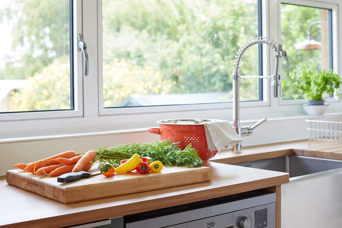 Prepare a meal in the kitchen while admiring the beautiful garden outlook.
