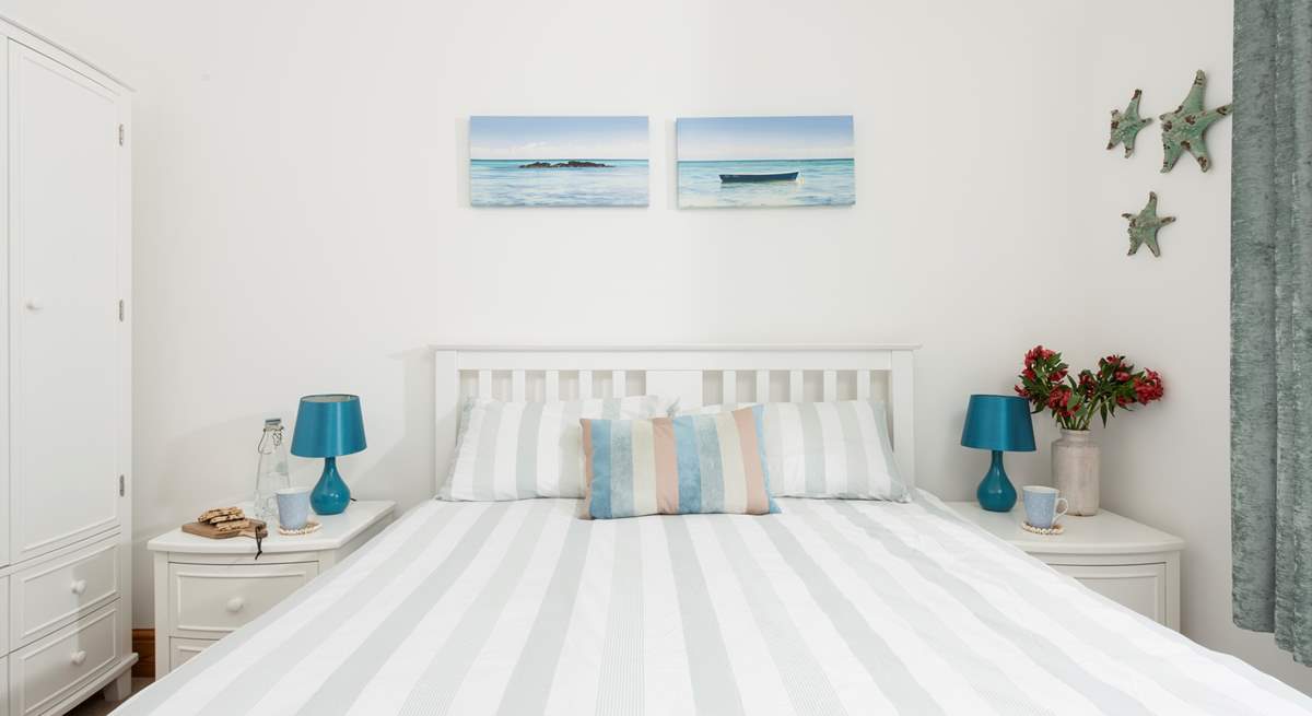Bedroom 1 features an oceanic palette. 