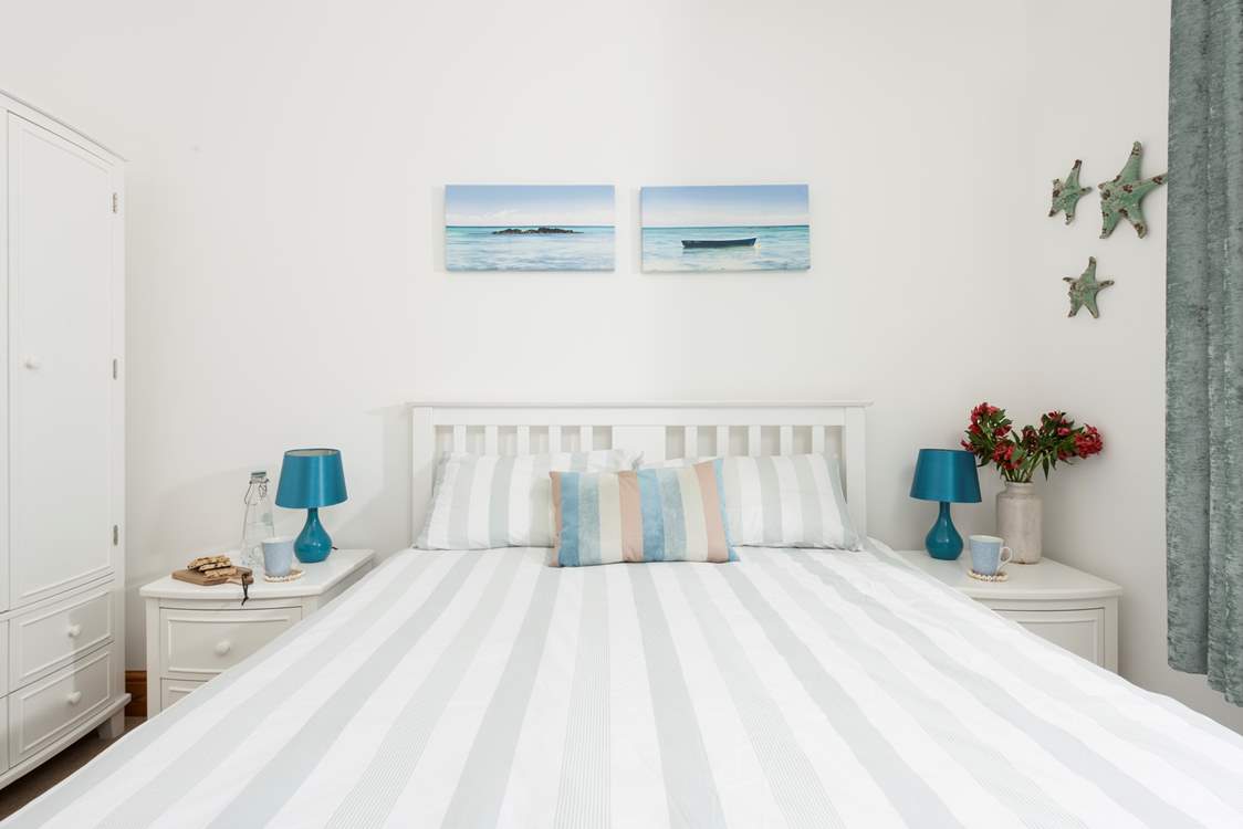Bedroom 1 features an oceanic palette.