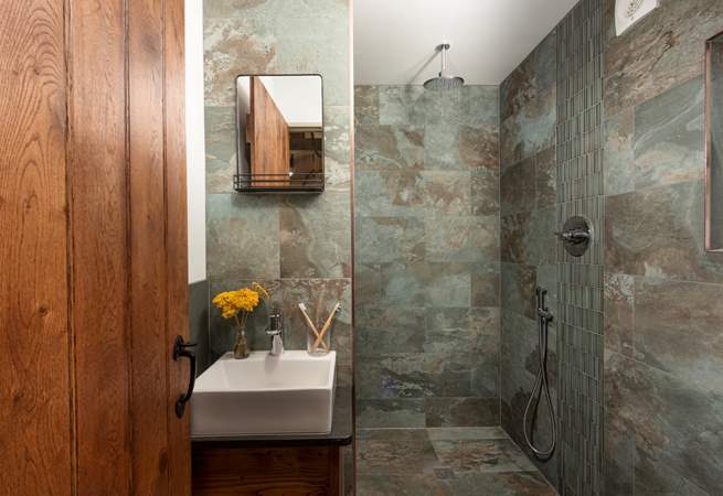 Refresh in the luxe bathroom with a waterfall shower, sink and WC.