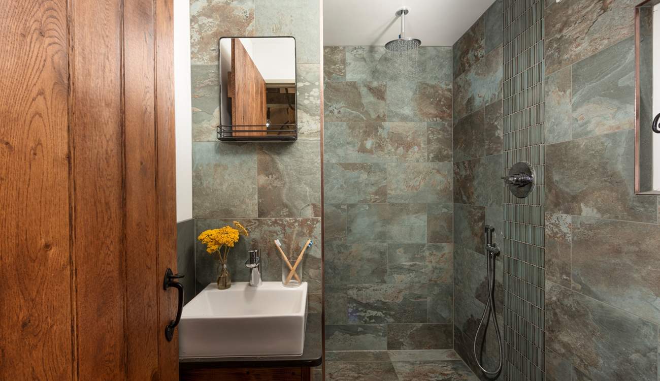 Refresh in the luxe bathroom with a waterfall shower, sink and WC.