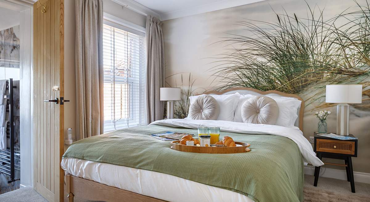 The relaxed principal bedroom with king-size bed and luxurious en suite bathroom.