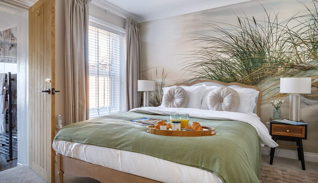 The relaxed principal bedroom with king-size bed and luxurious en suite bathroom.