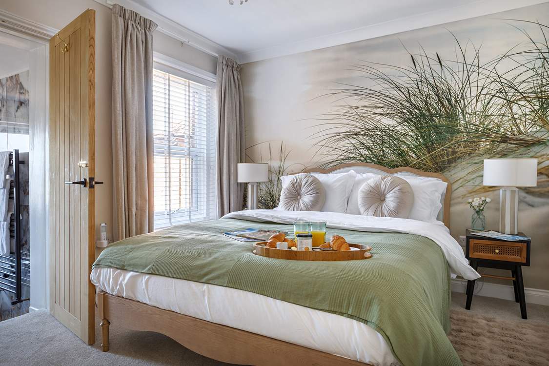 The relaxed principal bedroom with king-size bed and luxurious en suite bathroom.