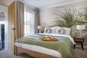 The relaxed principal bedroom with king-size bed and luxurious en suite bathroom.