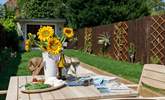 Enjoy the sunshine in the pretty garden; the summer-house is not available at the present time. - Thumbnail Image
