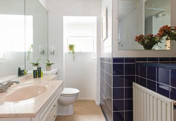 A traditional bathroom with bath and overhead shower.
