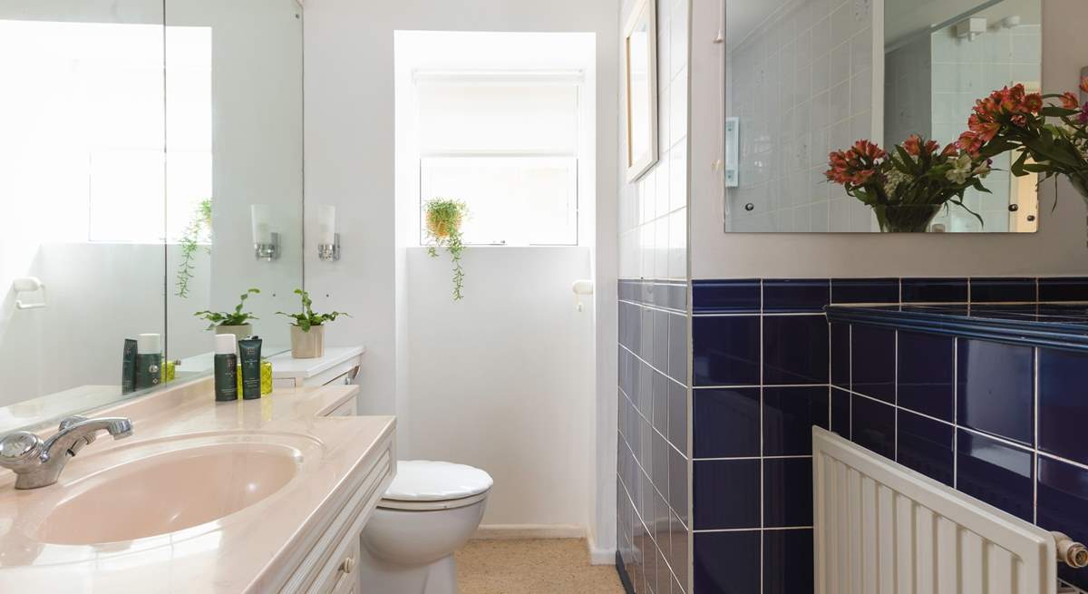 A traditional bathroom with bath and overhead shower.