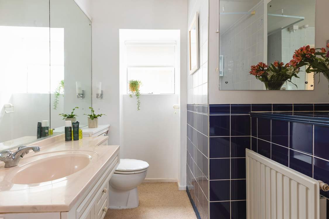 A traditional bathroom with bath and overhead shower.