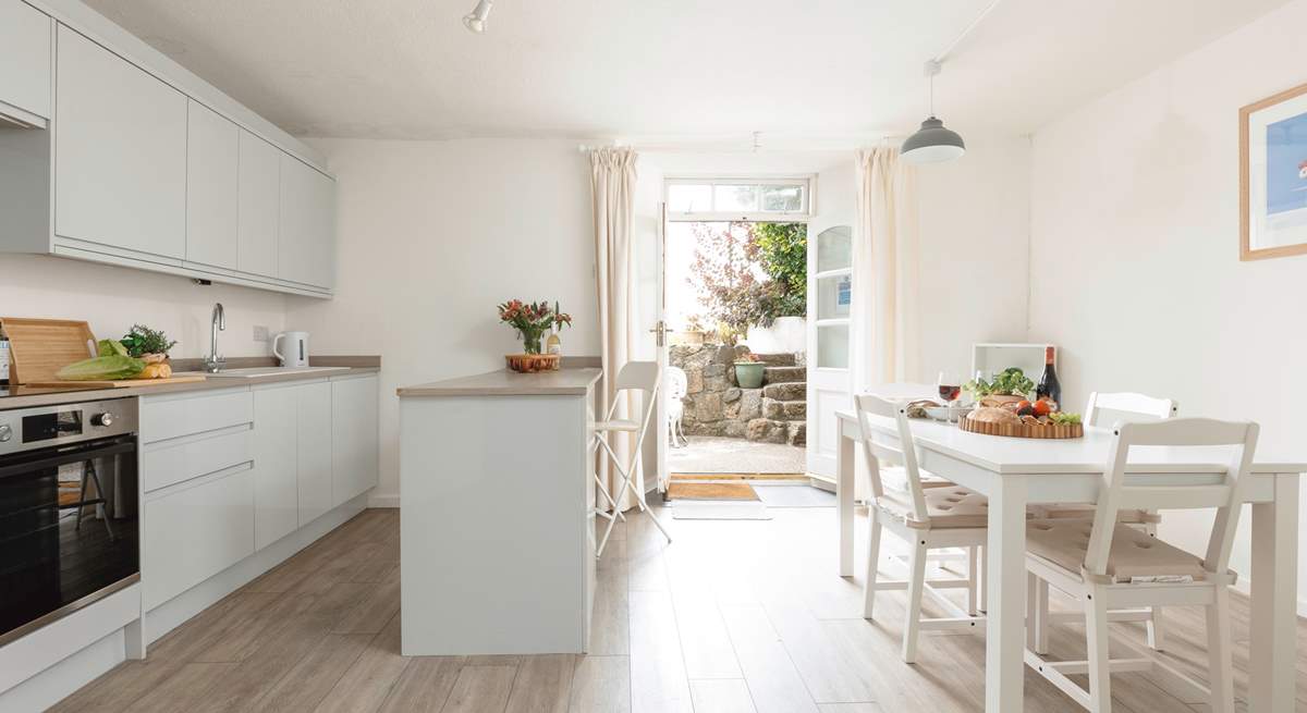 Enter the double doors into a very modern kitchen and dining area. The doors open onto a sweet private courtyard.