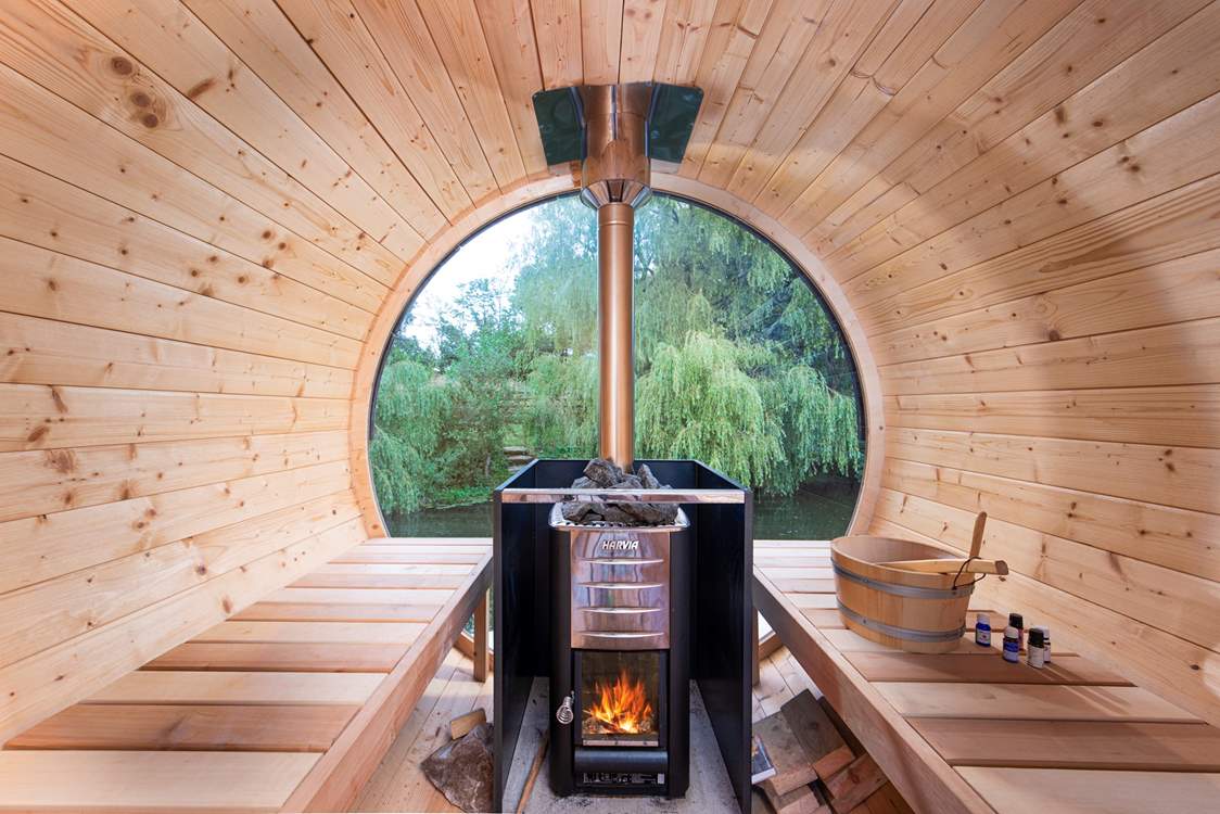 The shared wood-fired sauna looks out over the pond and willows.