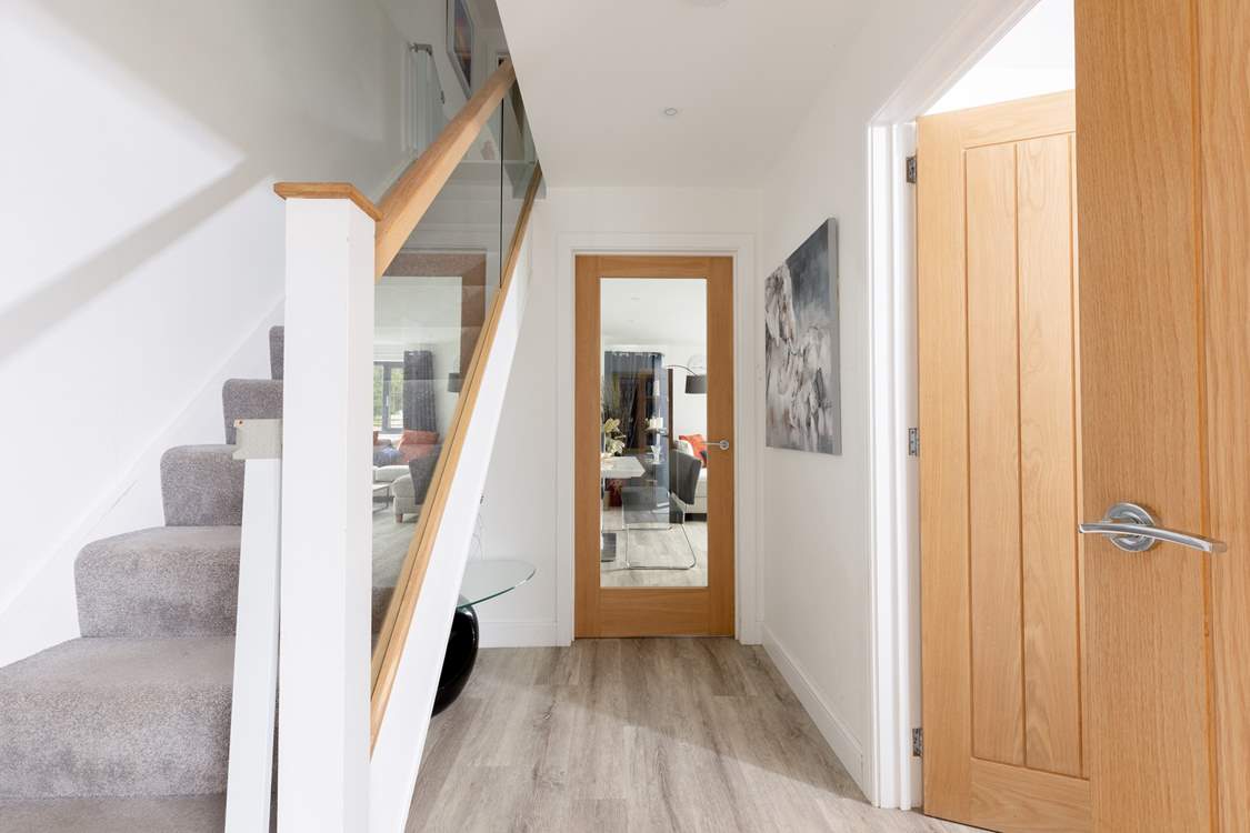 The entrance hall leading into the open plan living space. There is a utility-room on your left and a handy downstairs cloakroom.