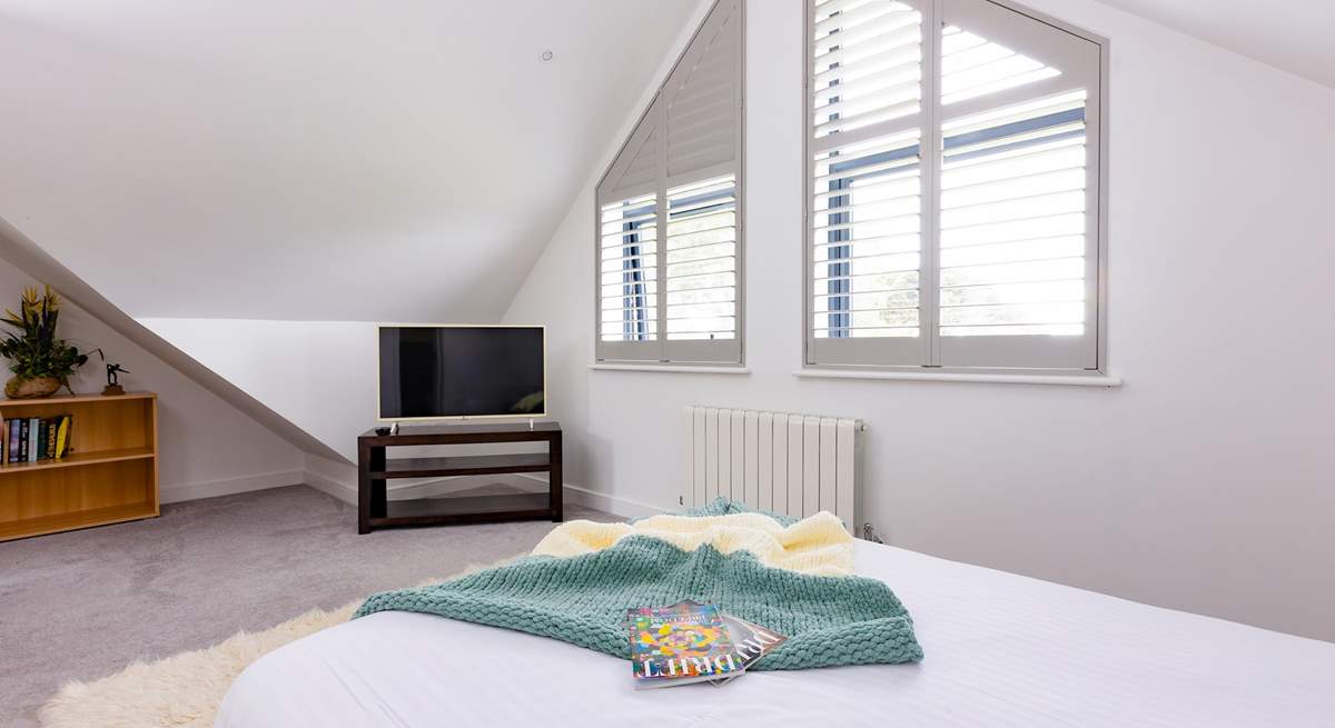 Wake up to a sunlit space and serene sea views in this contemporary double bedroom with an en suite shower-room.