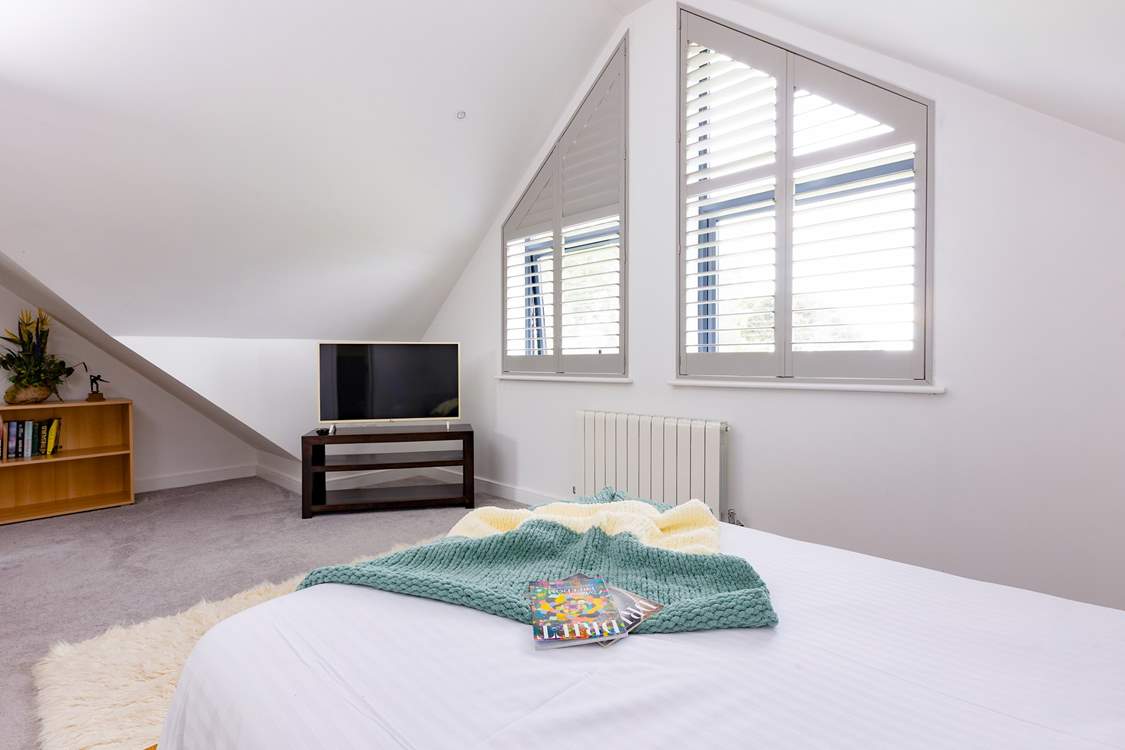 Wake up to a sunlit space and serene sea views in this contemporary double bedroom with an en suite shower-room.