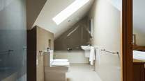 Exquisite bathroom with rainfall option shower and bath tub. Doors leading to the principal and twin bedrooms. 