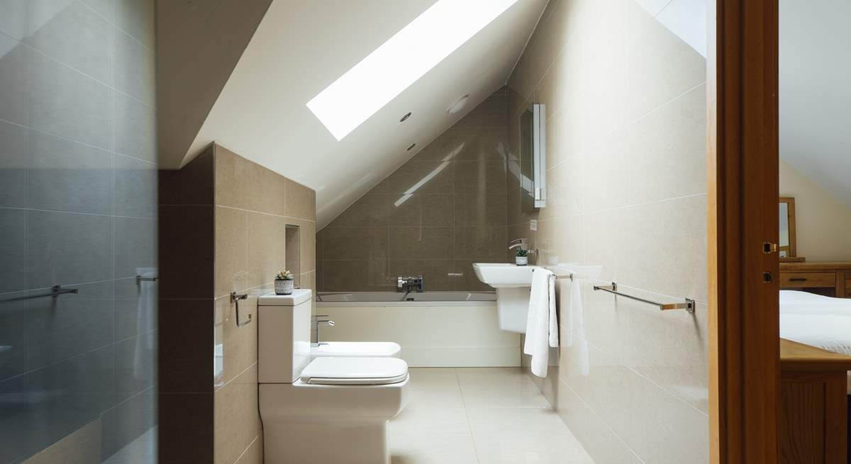 Exquisite bathroom with rainfall option shower and bath tub. Doors leading to the principal and twin bedrooms. 