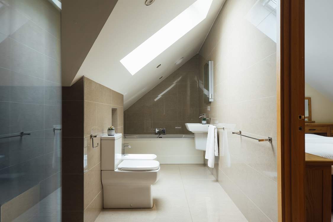Exquisite bathroom with rainfall option shower and bath tub. Doors leading to the principal and twin bedrooms.