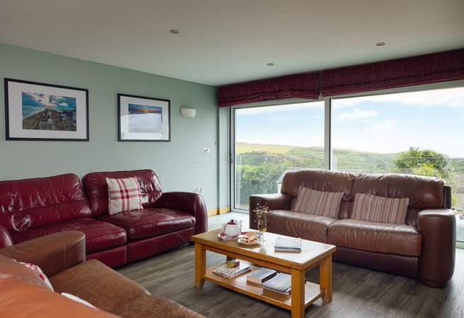 The stunning sea and rural views are drawn in through the large glass sliding doors in the first floor living-room. 
