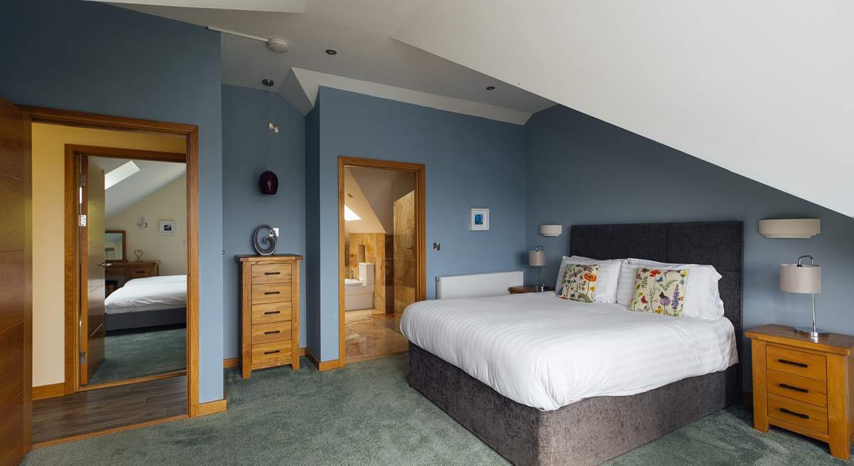 Spacious principal bedroom with luxurious bathroom and spectacular views across St Brides Bay. (Shared en suite, with doors from the principal and twin room on the second floor). 