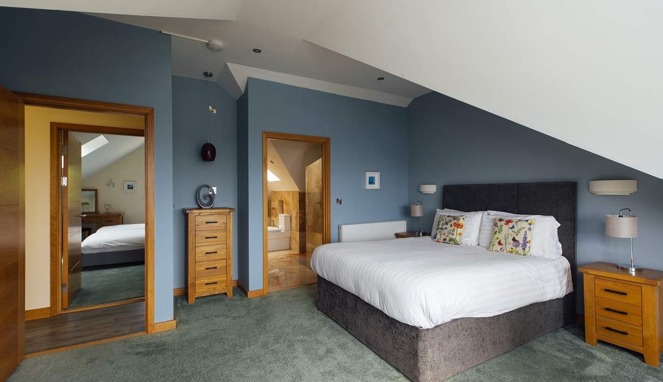 Spacious principal bedroom with luxurious bathroom and spectacular views across St Brides Bay. (Shared en suite, with doors from the principal and twin room on the second floor). 