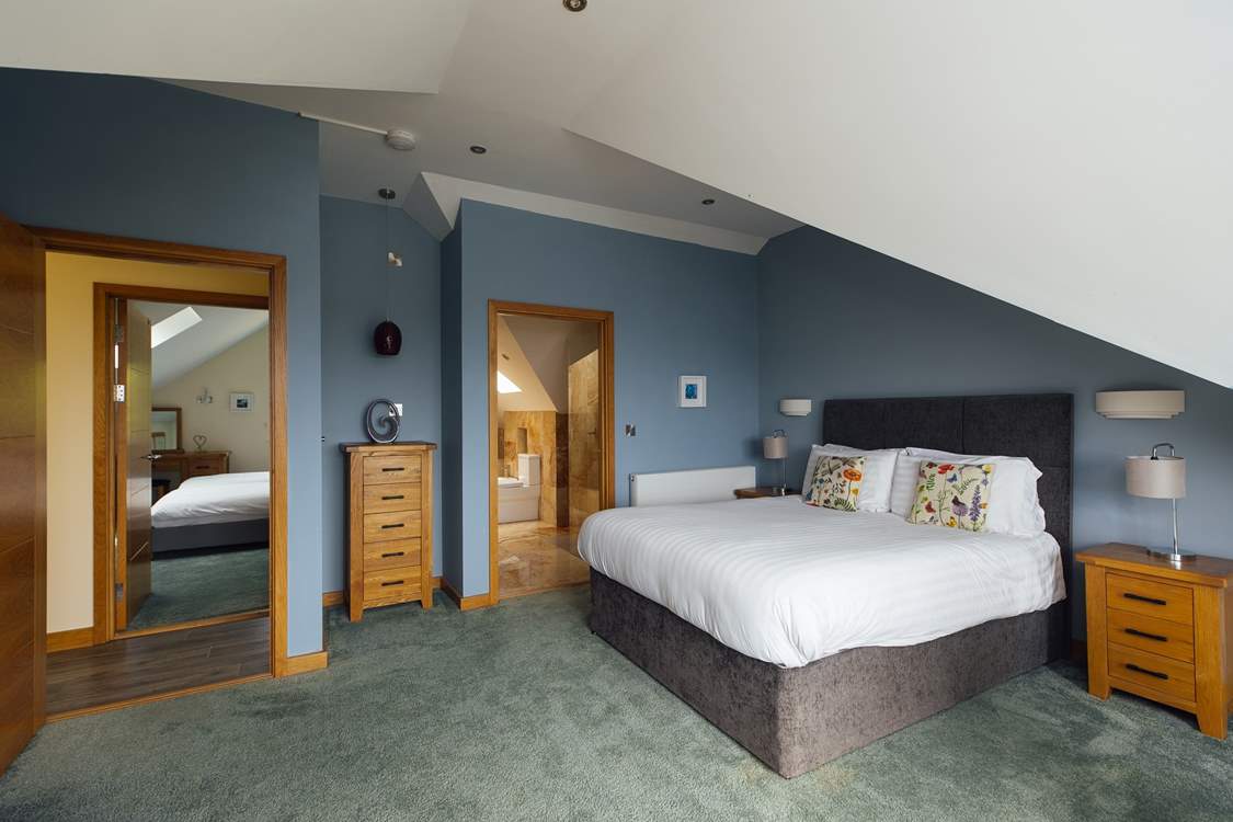 Spacious principal bedroom with luxurious bathroom and spectacular views across St Brides Bay. (Shared en suite, with doors from the principal and twin room on the second floor).