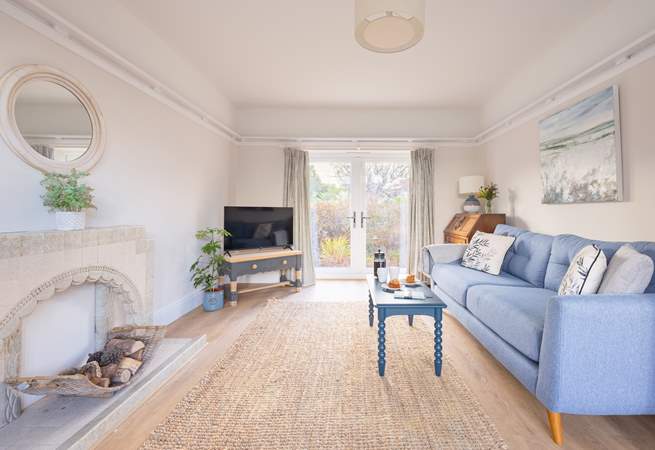 Double doors open from the living area to a small patio and garden.