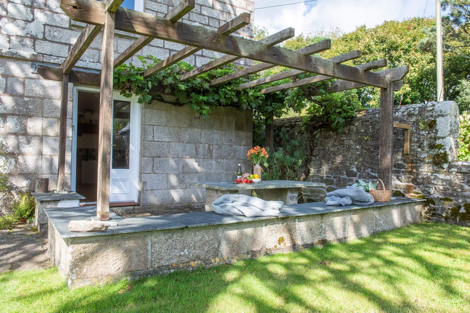 From the kitchen doors step outside and enjoy a glass of wine on the terrace under the established grape vine.