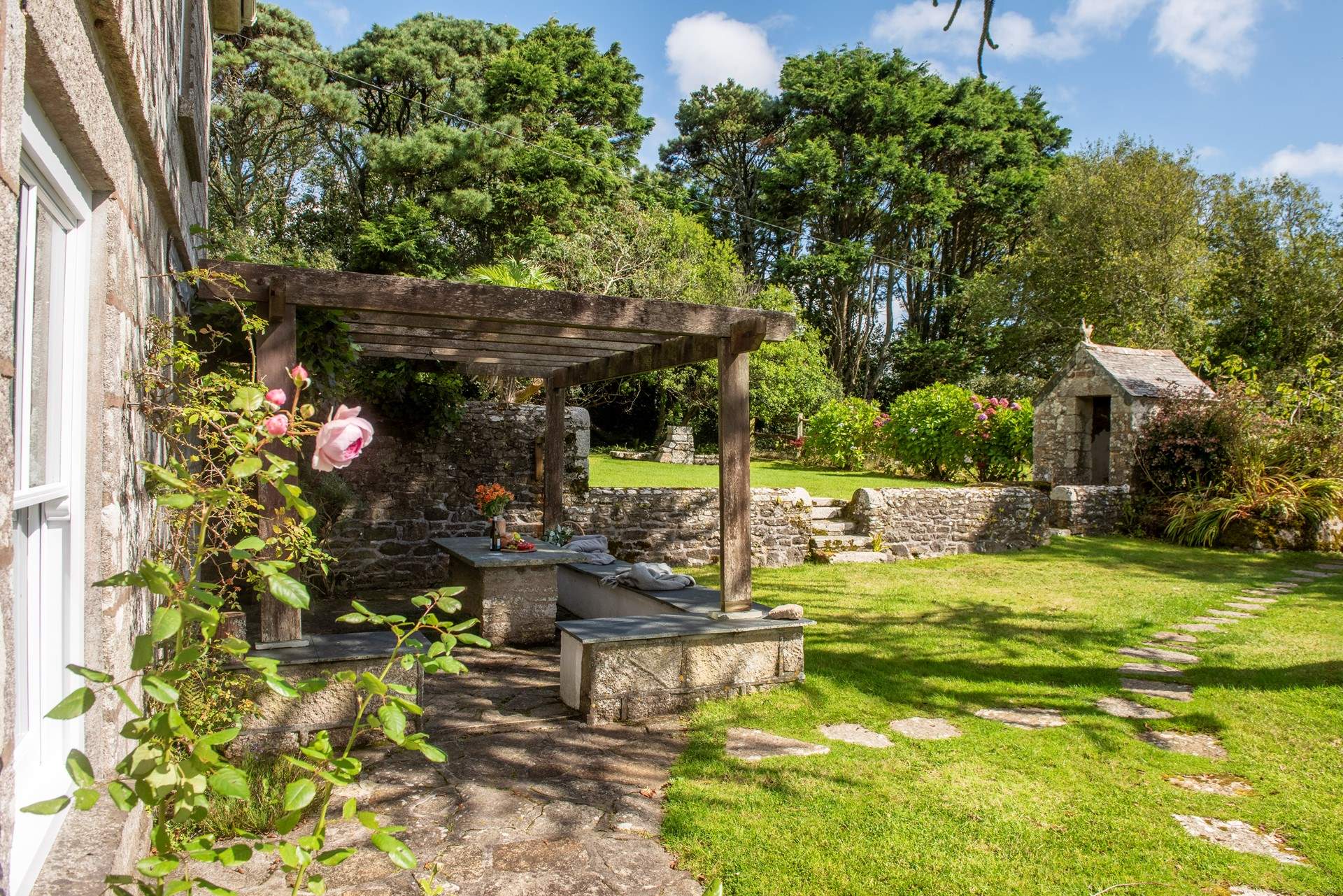 A charming country garden, filled with mature shrubs, roses and an abundance of fruit trees.