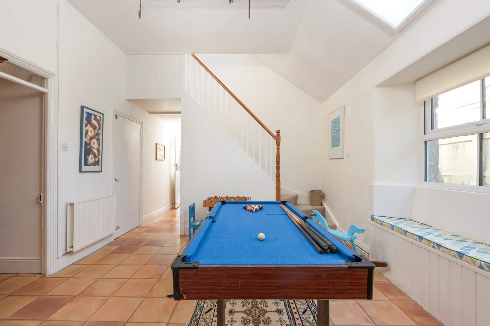 The utility-room is also an indoor games-area with a small pool table and the second staircase leading to the bedrooms.