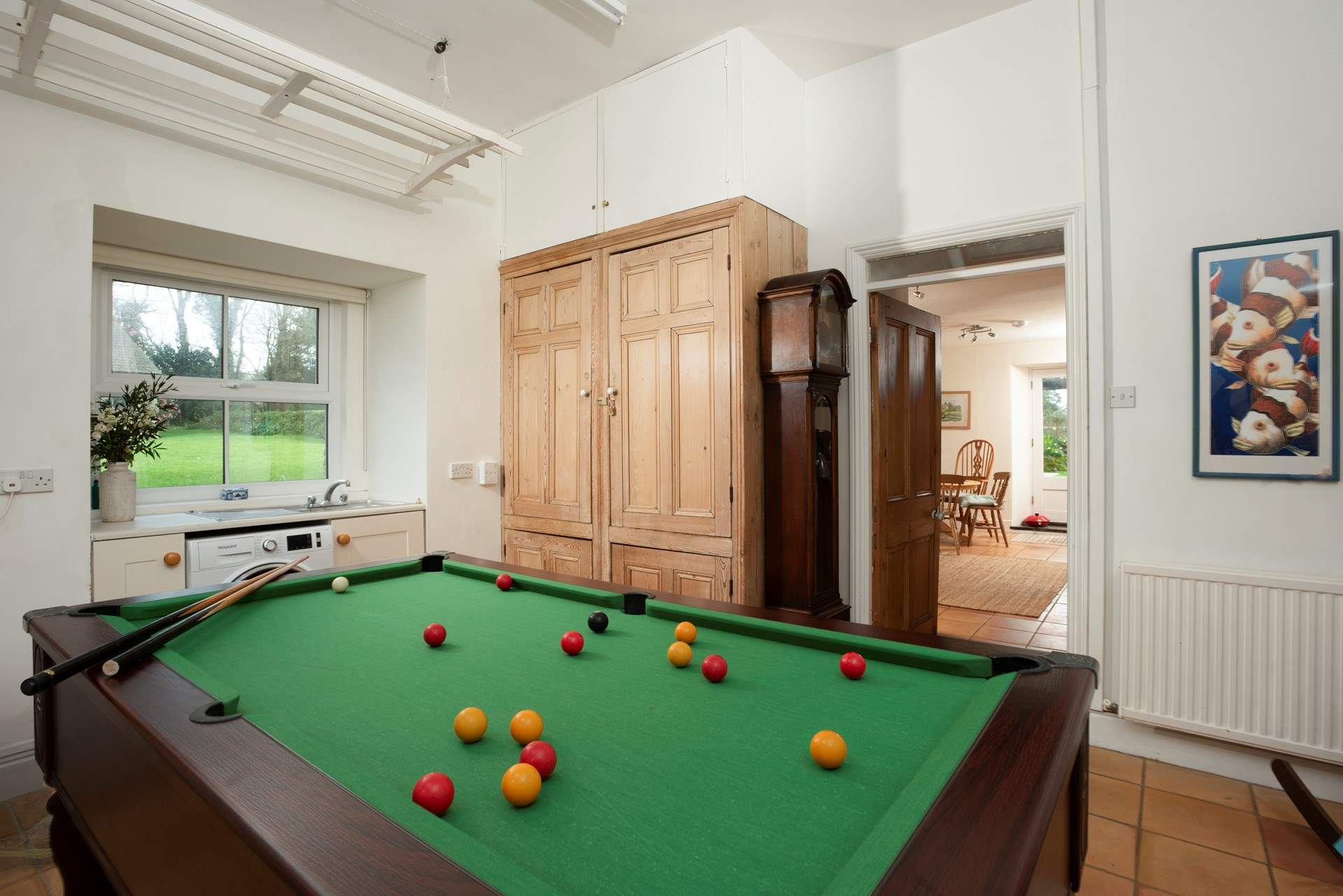 The utility-room is also an indoor games-area with a pool table and the second staircase leading to the bedrooms. 