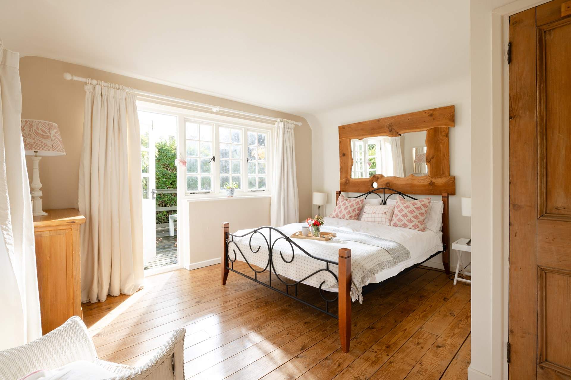 Bedroom 1 with its original wooden floor leads out onto the raised seating-area, just the place for a morning coffee. 