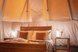 The comfy double bed is adorned with cushions and throws for ultimate relaxation.