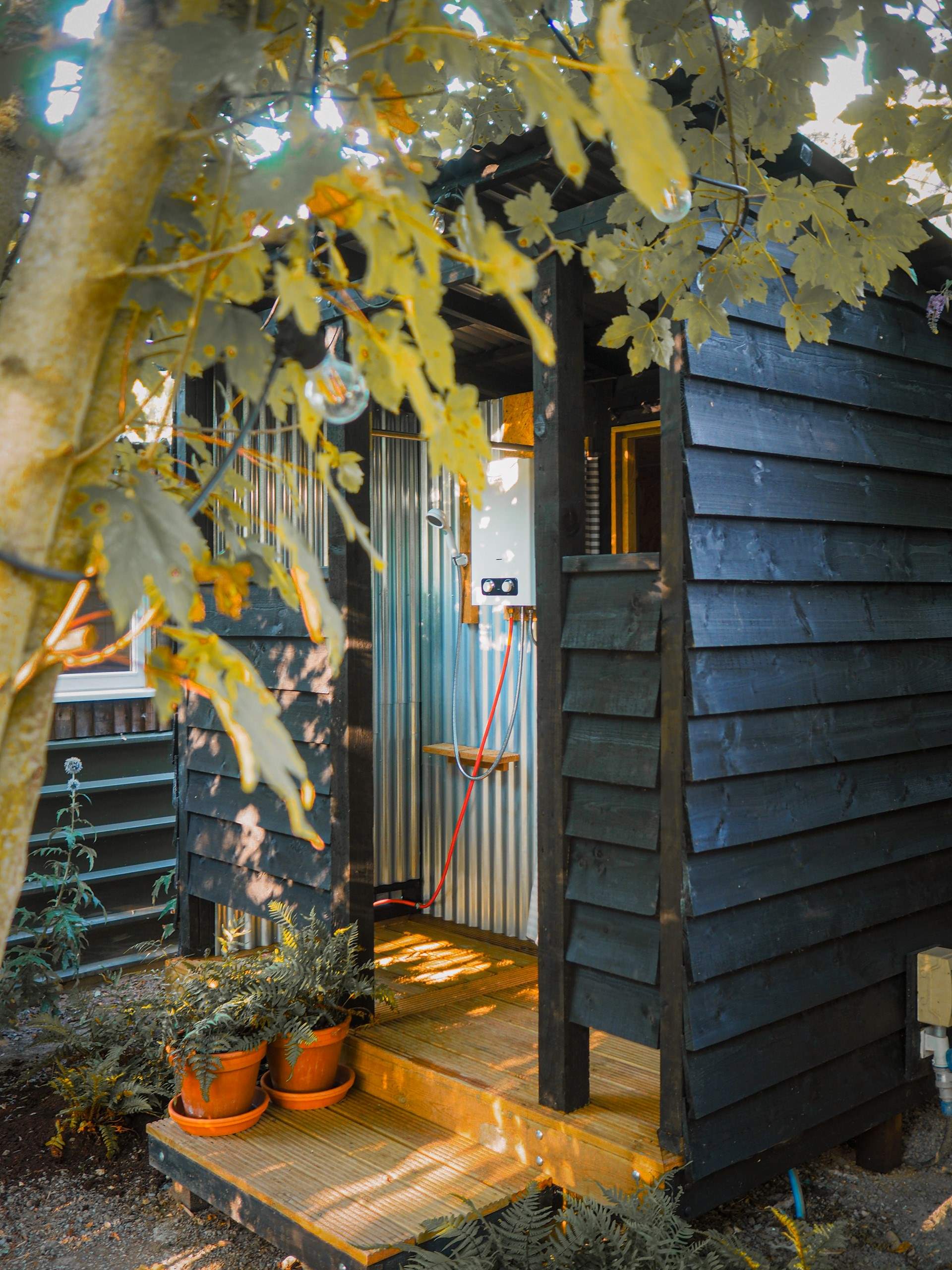 A private outdoor restroom and shower room sits to the rear of the tipi.