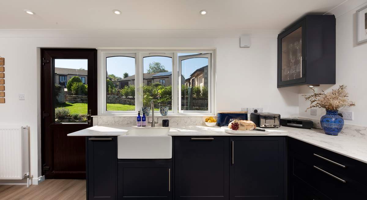 A very modern kitchen and dining area flooded with light and overlooking the garden.