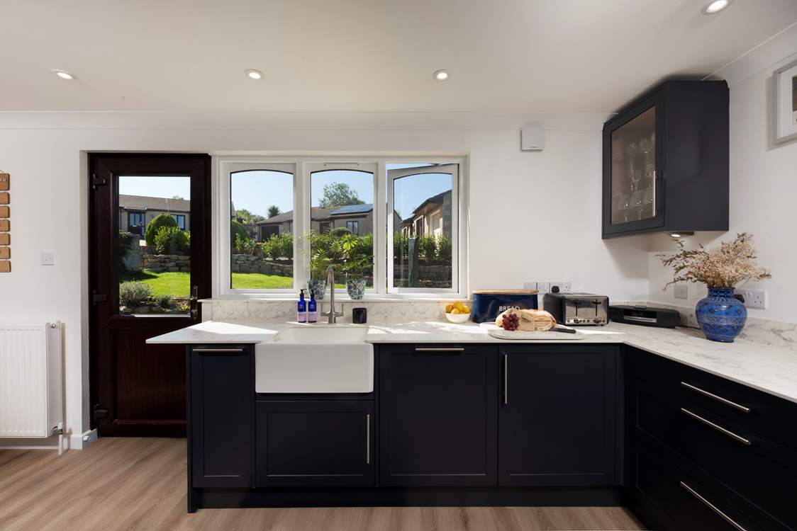 A very modern kitchen and dining area flooded with light and overlooking the sweet garden.