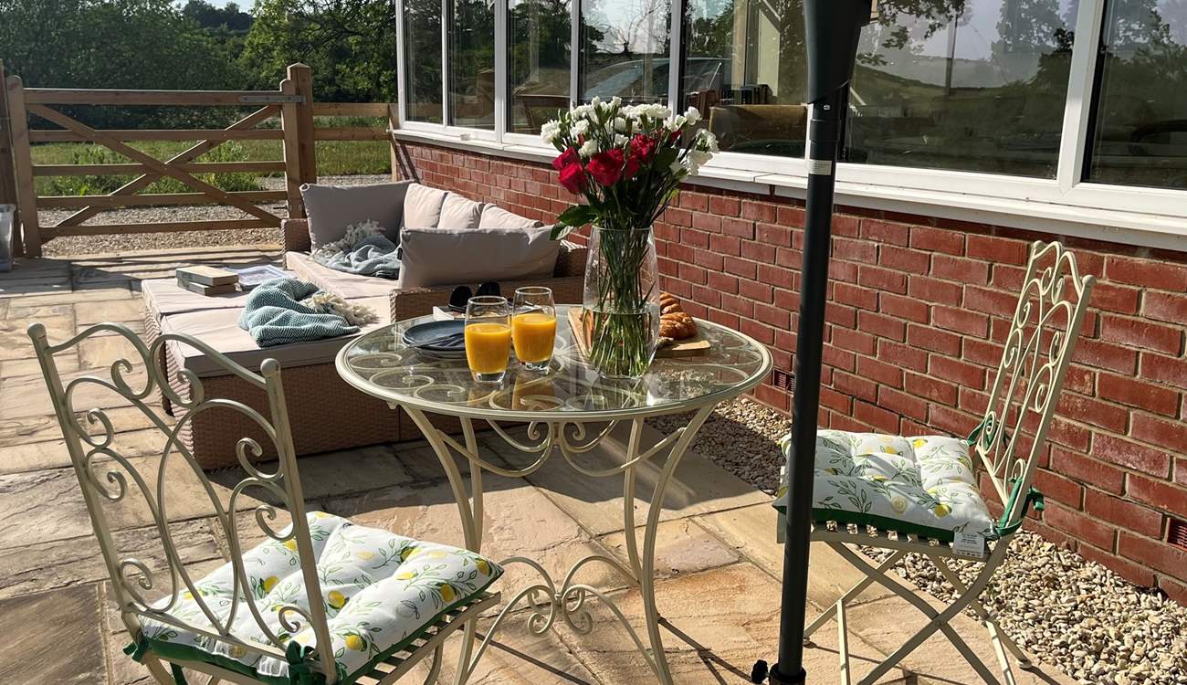 A bistro table for two and a comfy outdoor sofa, all surrounded by the sounds of nature.