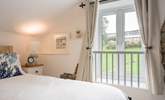 Bedroom 2 has views out to the communal area and swimming pool building. - Thumbnail Image