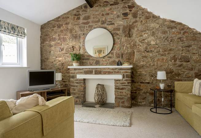 The sitting-room with original stonework and beams.