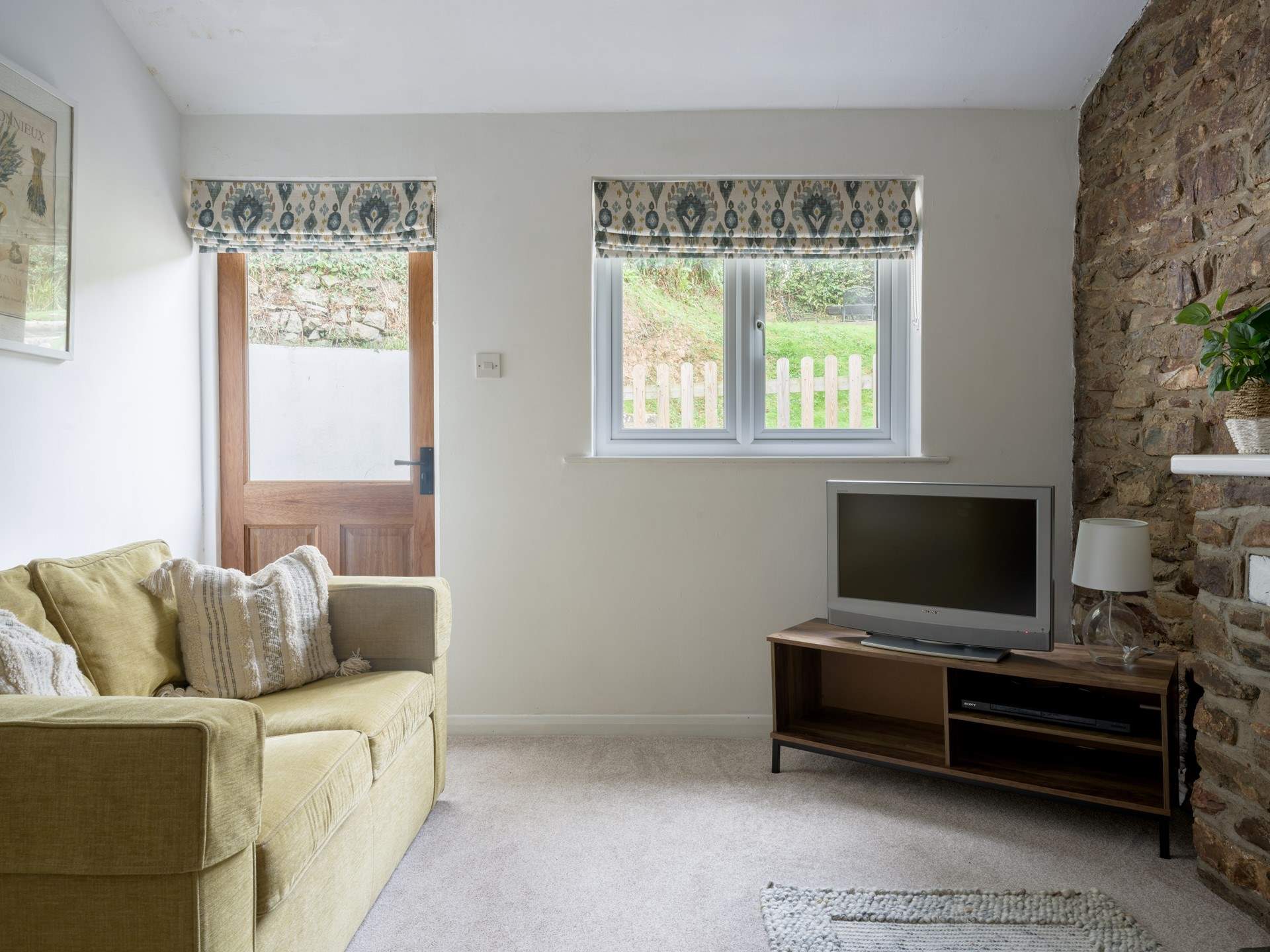 Snuggle down in front of the TV after a day of exploring. The door leads out to your garden.